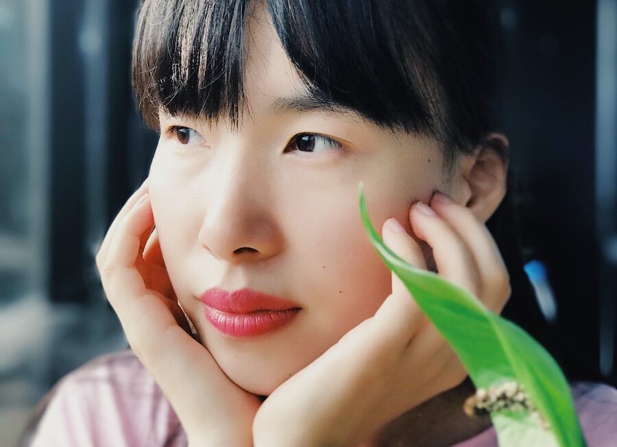 selective focus photography of woman wearing watch and pink scoop-neck shirt